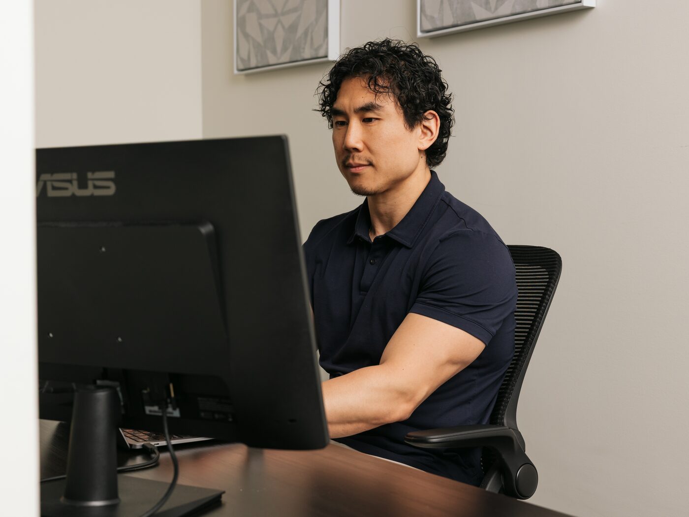 David Chung focused on his screen at his desk