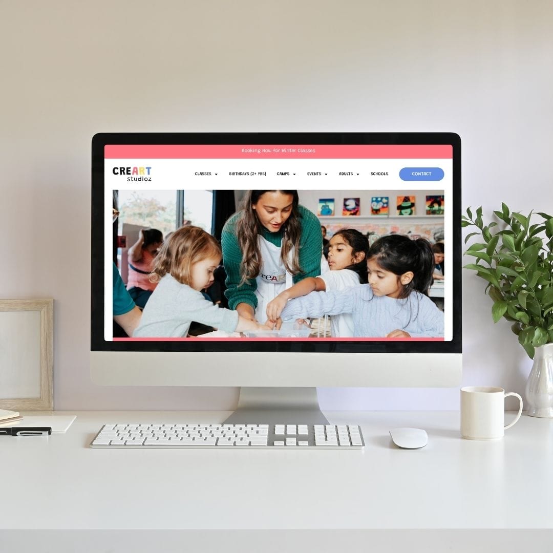 Computer on desk displaying CreArt Studioz website with children doing art activity