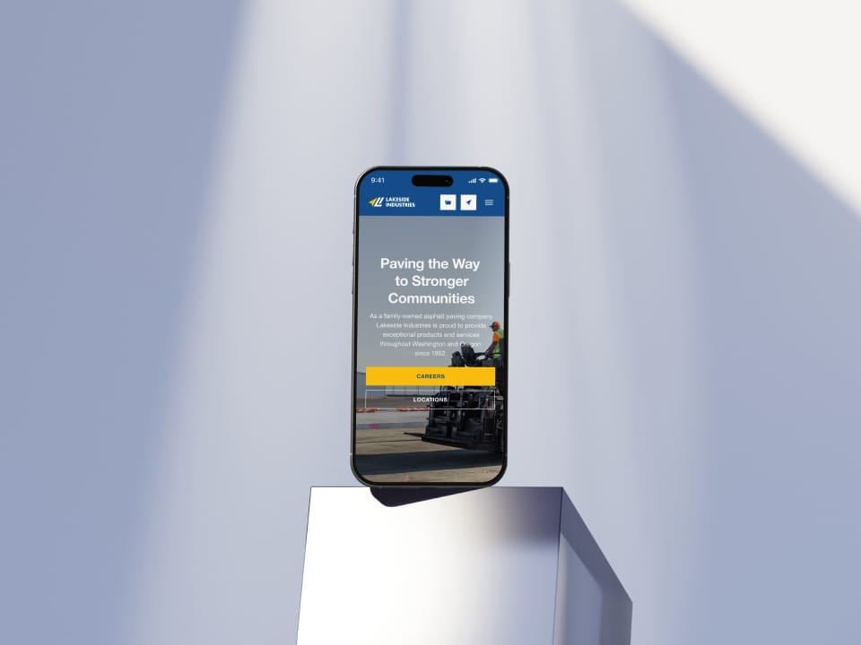 Smartphone displaying Lakeside Industries website on metallic pedestal