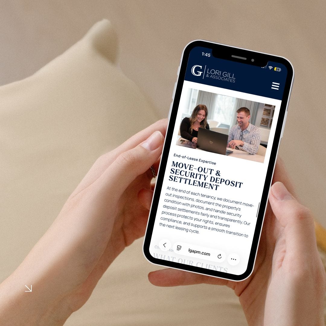 Person holding phone displaying Lori Gill website