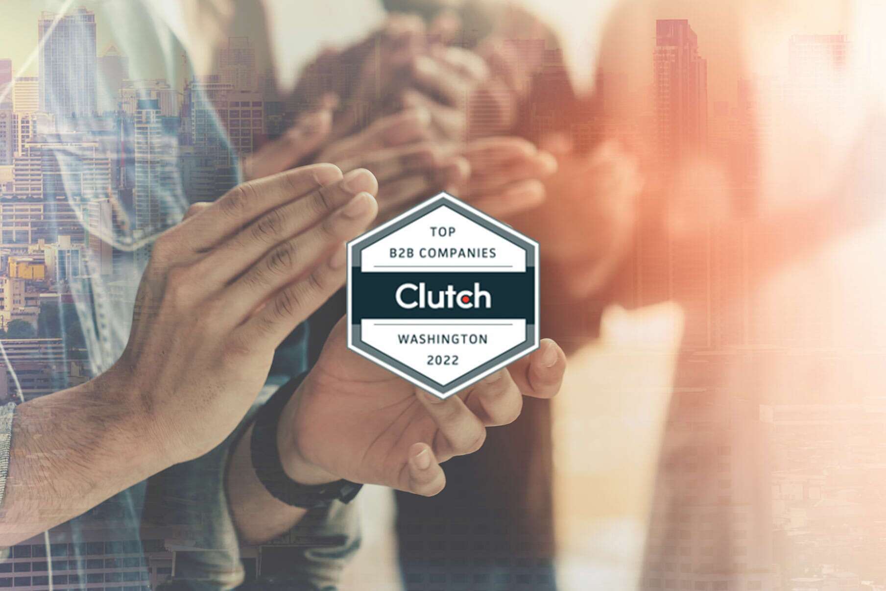 People clapping in the background with a badge in the foreground reading Top B2B Companies, Clutch, Washington, 2022. The image has a warm, cityscape overlay.