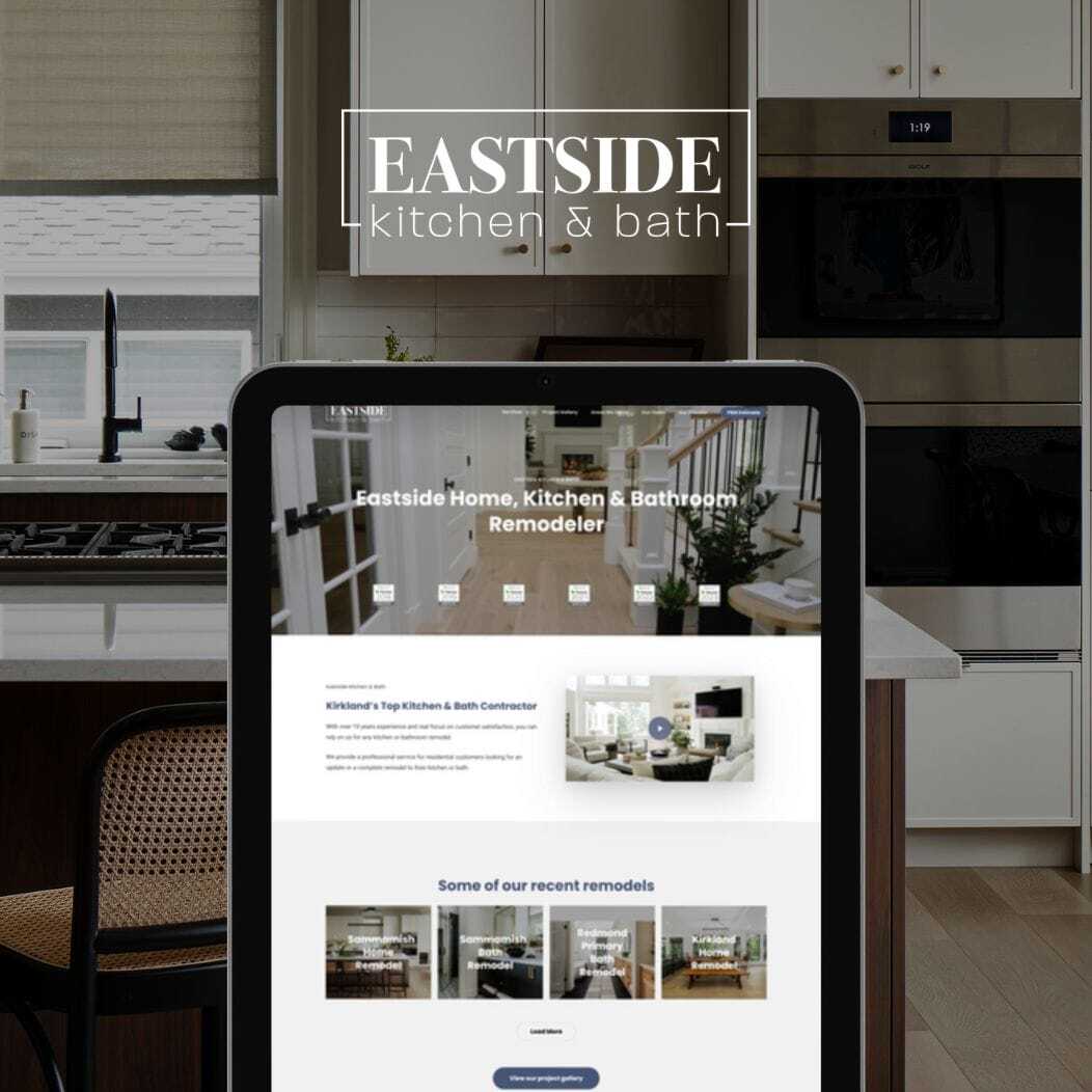 A tablet displaying a website for Eastside Kitchen & Bath, featuring images of renovated kitchens and bathrooms. The background shows a modern kitchen with sleek appliances and cabinetry. The brands logo is prominently displayed at the top.