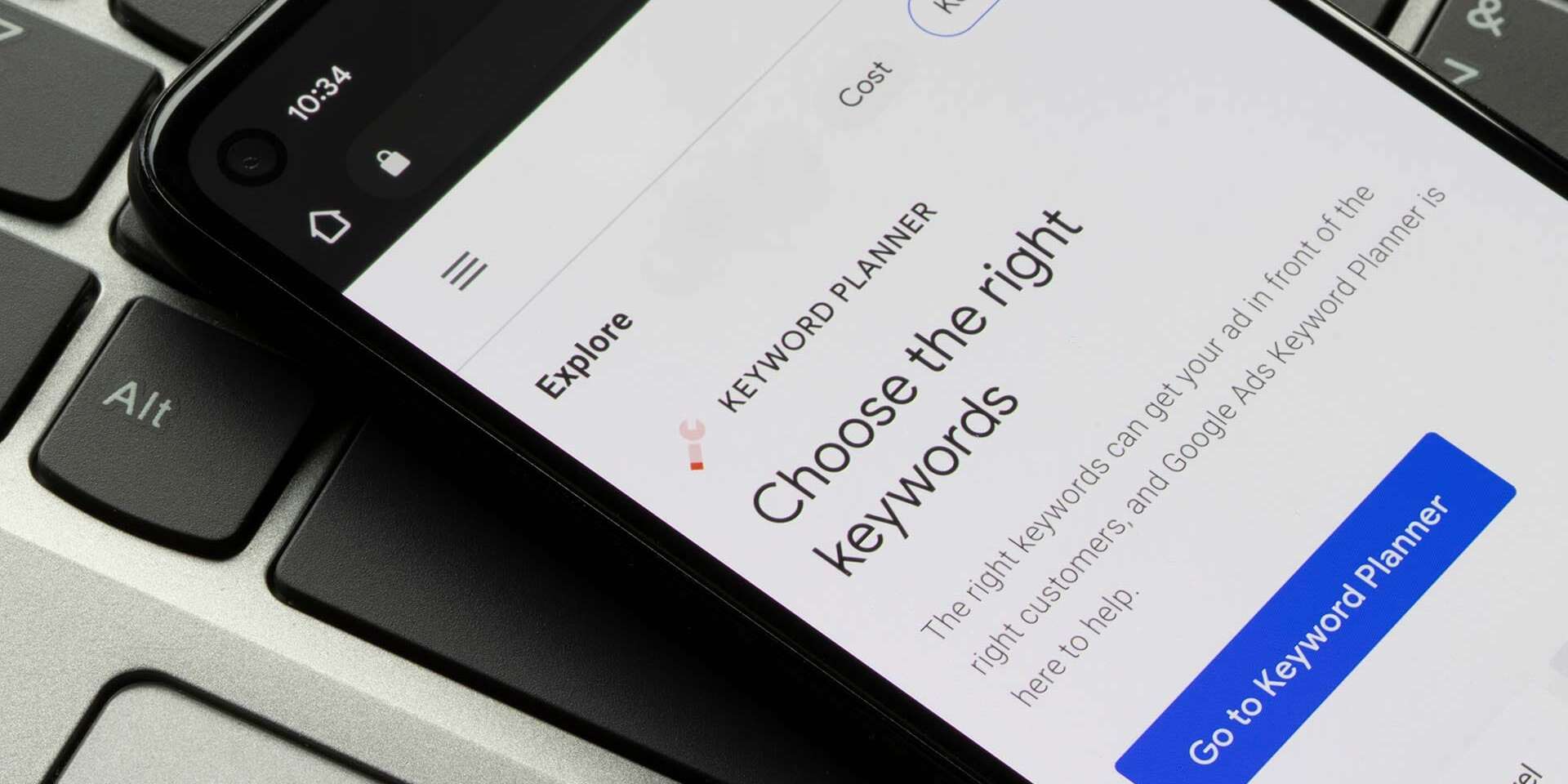 Smartphone displaying Google Ads Keyword Planner with the text Choose the right keywords on the screen. Its resting on a laptop keyboard.