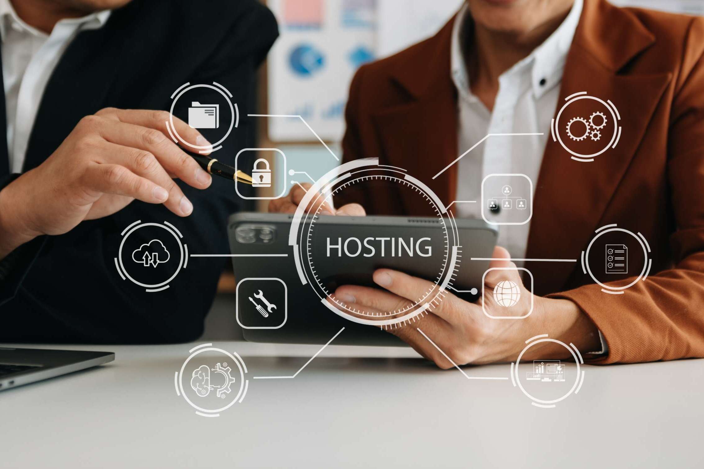 Two people are discussing hosting services, with one holding a smartphone. Overlay icons represent concepts like security, cloud storage, and settings. A laptop is visible on the table. The word HOSTING is highlighted in the center.