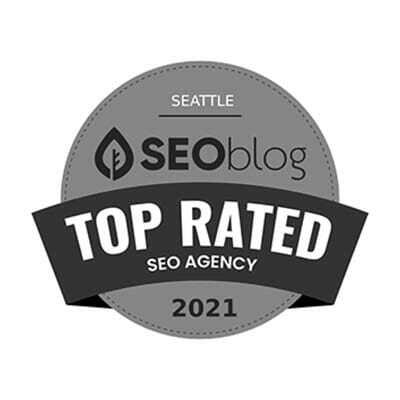 Gray circular badge displaying Seattle SEOblog Top Rated SEO Agency 2021 with a leaf icon.