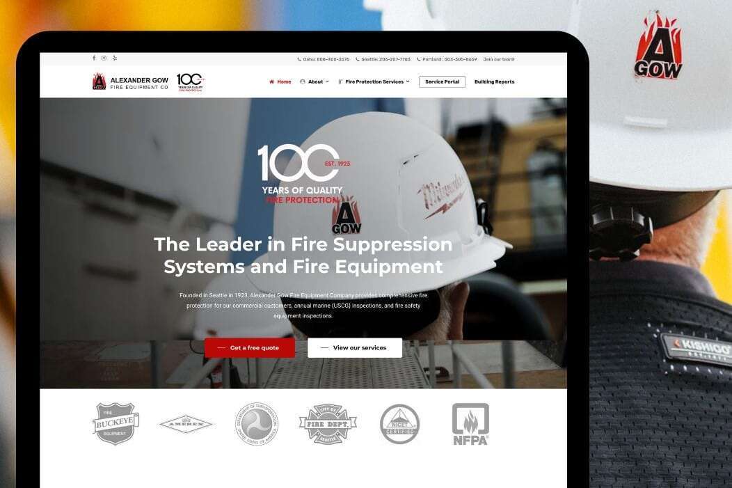 A website on a tablet screen displaying Alexander Gow Fire Equipment with a focus on fire suppression systems. The background shows a worker in a hard hat with a company logo. .