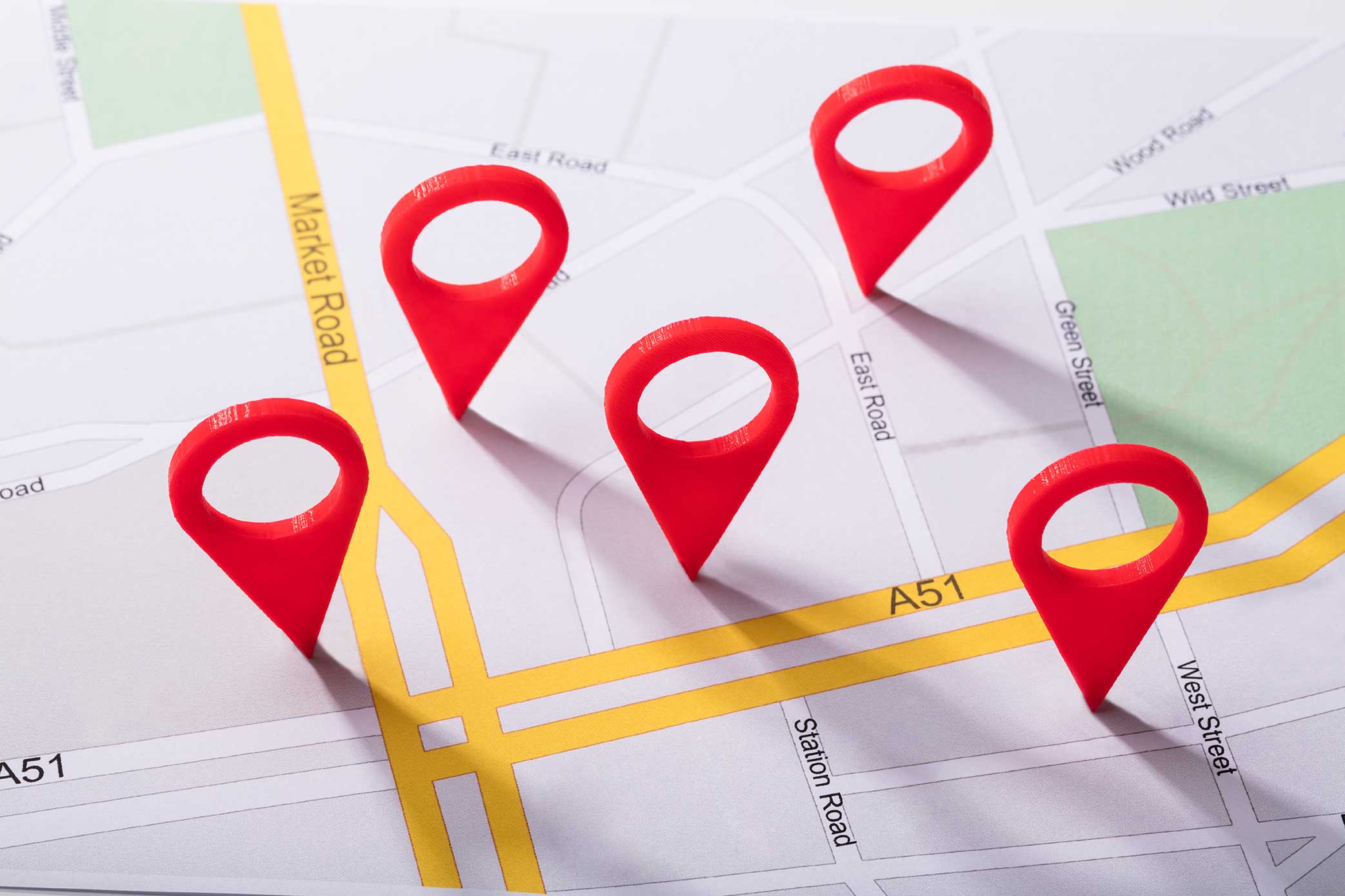A map with several red location pins placed on various streets, including Market Road, East Road, Green Street, and Station Road. Yellow highlighted roads intersect the map.