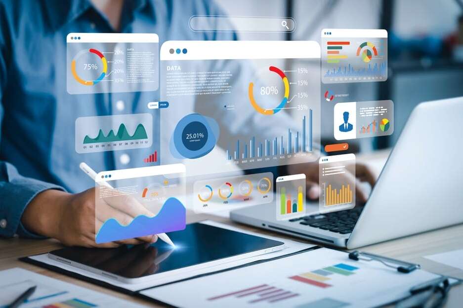 A person using a tablet and laptop displays various colorful graphs and charts. The floating analytics include pie charts, bar charts, and line graphs, illustrating data analysis and statistics in a digital workspace.