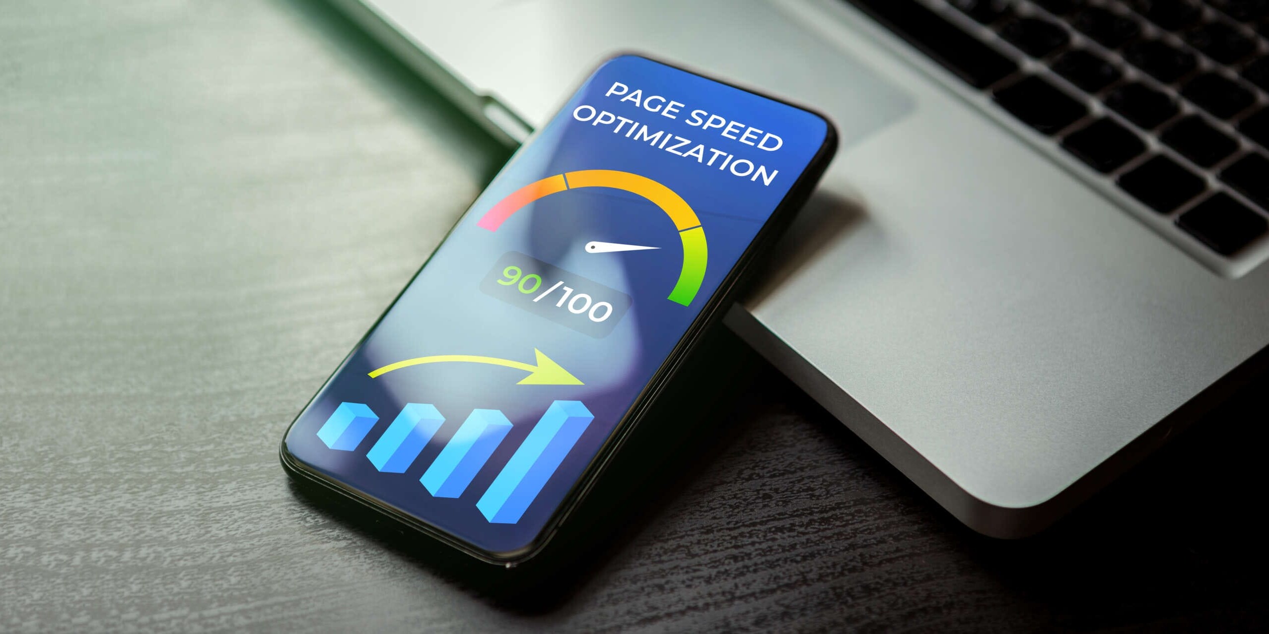 Smartphone on a laptop displaying a Page Speed Optimization screen with a speedometer graphic showing a score of 90/100 and a bar chart indicating upward progress.