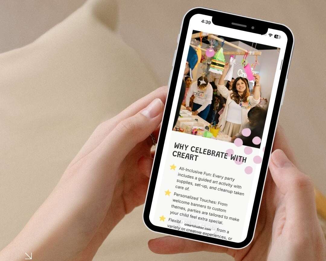 A person holds a smartphone showing a website page titled WHY CELEBRATE WITH CREART with a photo of a smiling woman at a party and colorful decorations, while sitting on a beige couch.